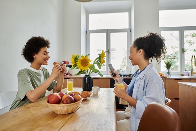 Momentos alegres de una hermosa pareja de lesbianas compartiendo el desayuno en una cocina brillante