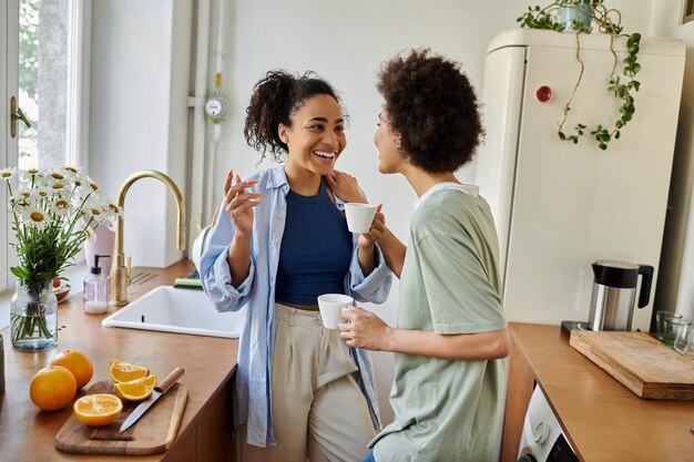 Momentos cálidos de una hermosa pareja de lesbianas disfrutando del té juntos en su acogedora cocina