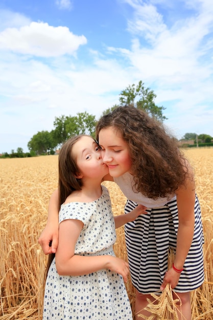 Momentos felices de la familia - Chicas jóvenes divirtiéndose en el campo de trigo