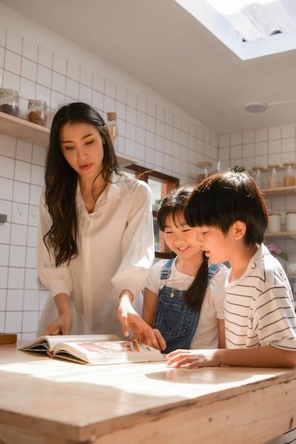 Momentos felices de la familia cuando los niños ayudan a mamá a cocinar en la cocina