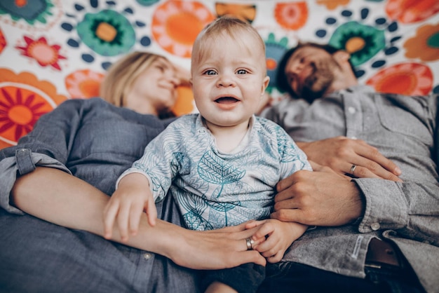 Momentos felizes em família família hipster de férias de verão brincando com filho bonitinho na rede no parque ensolarado de verão mãe elegante e pai com criança espaço relaxante para texto