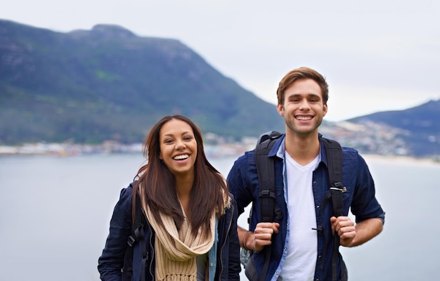 Momentos de la naturaleza juntos Una feliz pareja joven con mochilas disfrutando de la naturaleza