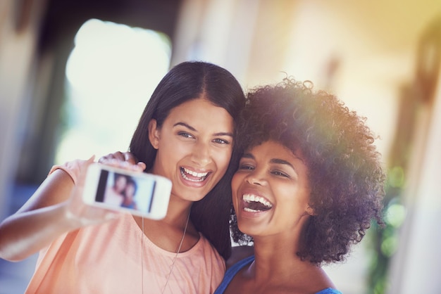 Momentos para recordar foto de dos amigas haciéndose un selfie con un teléfono móvil