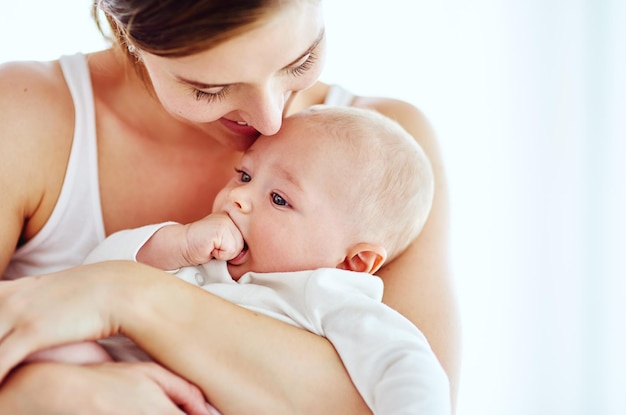 Momentos tiernos con mamá Fotografía de un adorable bebé que se une a su madre en casa