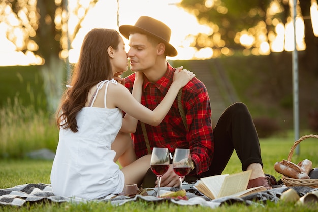 Momentos tiernos. Pareja joven caucásica disfrutando juntos de fin de semana en el parque el día de verano. Luce encantadora, feliz, alegre. Concepto de amor, relación, bienestar, estilo de vida. Emociones sinceras.