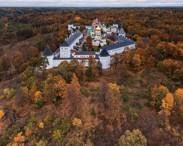 Monasterio ortodoxo ruso detrás de paredes encaladas rodeadas de árboles de otoño Zvenigorod Rusia