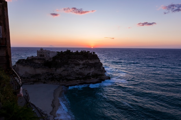 Monasterio del siglo en la cima del santuario de la isla de Santa María durante la puesta de sol Tropea