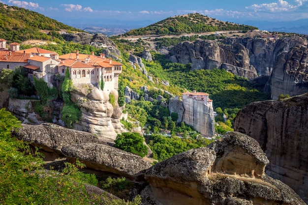 Foto monasterios de meteora grecia vista panorámica del santo monasterio de varlaam ubicado en el borde de una roca alta el área de meteora está en el patrimonio mundial de la unesco grecia europa