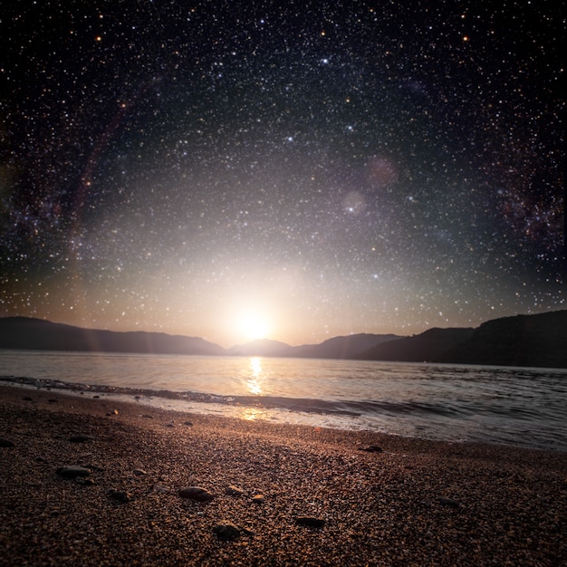 Monat auf einem Hintergrundsternhimmel, der im Meer reflektiert wird