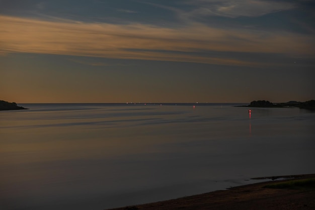 Mondaufgang über dem Fluss am Sternenhimmel in leichten Wolken. Nachtlandschaft