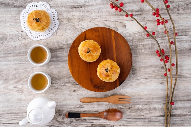 Mondkuchen Eigelb Gebäck Mooncake für MidAutumn Festival Urlaub Draufsicht Designkonzept auf hellem Holztisch mit Kopierraum flach über dem Kopf geschossen