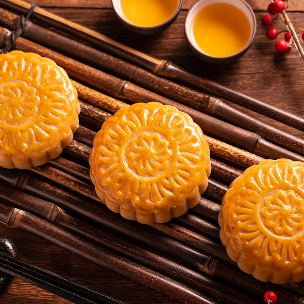 Mondkuchen Mooncake Tischdekoration Rundes chinesisches traditionelles Gebäck mit Teetassen auf Holzhintergrund MidAutumn Festival Konzept hautnah