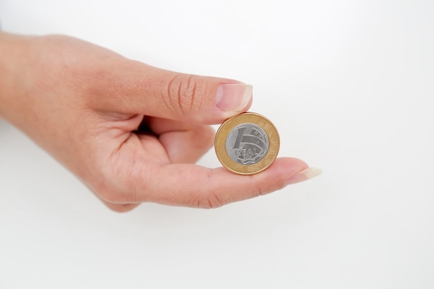 Moneda de 1 real brasileño en una mano de mujer