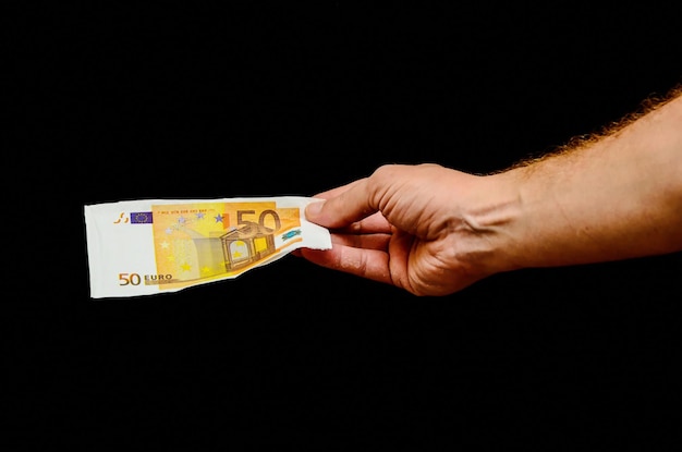 Moneda de billetes de dinero en euros europeos y mano derecha