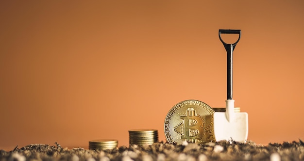 Moneda de bitcoin dorada y pila de moneda de dinero en el suelo con pala Concepto de bitcoin de minería