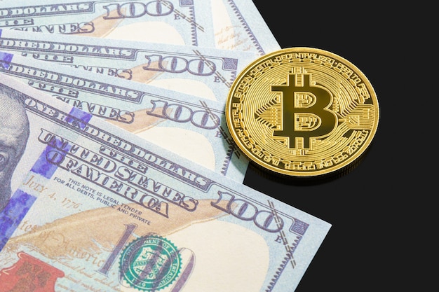 Moneda bitcoin de oro y billetes de cerca sobre fondo negro