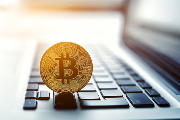 Moneda Bitcoin de oro en el teclado del portátil. Concepto comercial