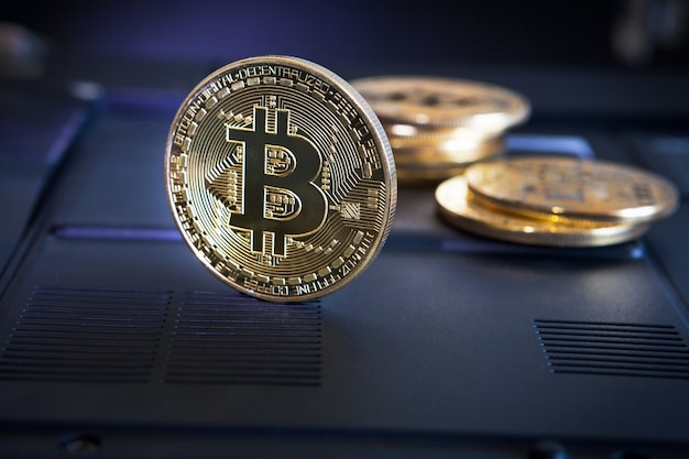 Moneda Bitcoin en superficie negra. Criptomoneda Bitcoin en una superficie de computadora.