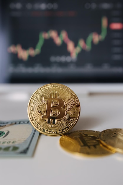 Moneda criptográfica de bitcoin de oro y dólares estadounidenses en el fondo de la tableta con inversión en el diagrama de acciones