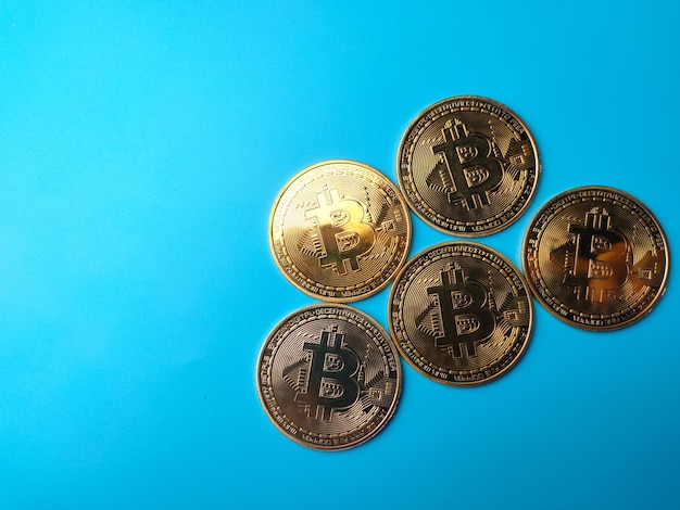 Moneda criptográfica Bitcoins en un fondo azul con espacio de copia para texto y diseño