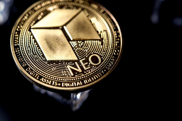 Moneda de criptomoneda Golden Neo Golden sobre fondo negro oscuro con cubitos de hielo