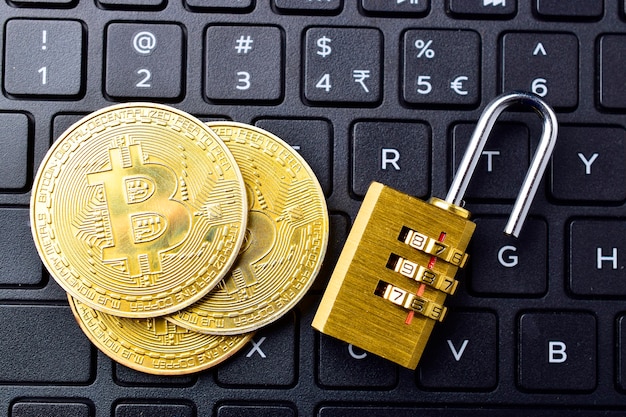 Moneda digital, bitcoin con candado en el teclado, concepto de rotura de blockchain