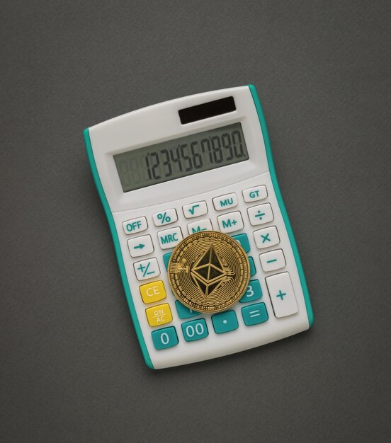 Moneda digital en una calculadora blanca sobre un fondo gris oscuro. El concepto de asentamientos en moneda digital.