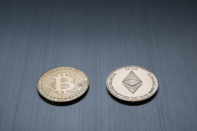Una moneda dorada de bitcoin y ethereum sobre un fondo metálico