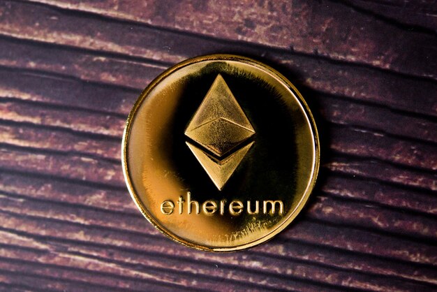 Moneda Ethereum ETH de oro y plata Nuevo dinero virtual Macro disparado sobre fondo de madera marrón oscuro