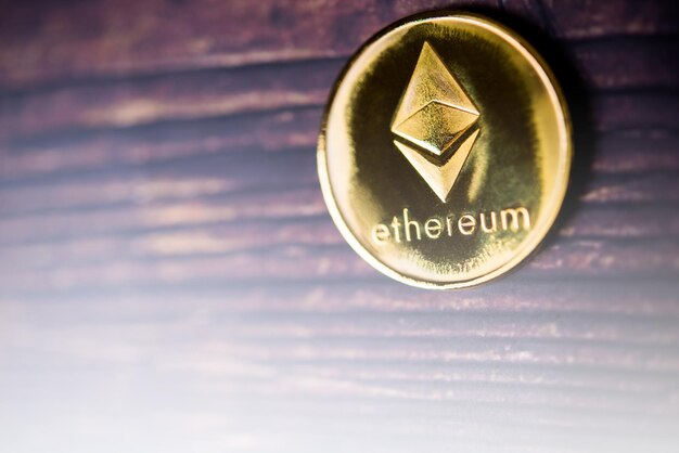 Moneda Ethereum ETH de oro y plata Nuevo dinero virtual Macro disparado sobre fondo de madera marrón oscuro
