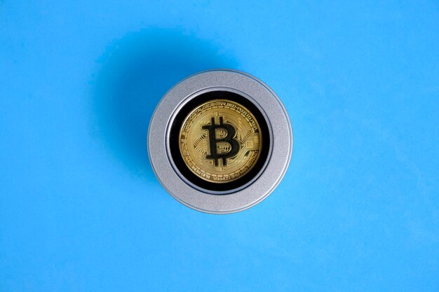 Moneda de oro bitcoin en caja de regalo fondo azul.