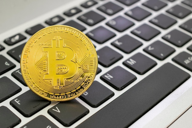 Moneda de oro Bitcoin en el teclado de la computadora. Concepto de criptomoneda virtual.