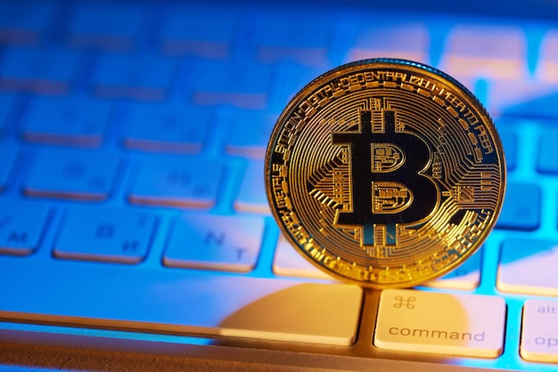 Moneda de oro bitcoin en el teclado con luz de neón