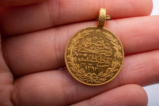 Moneda de oro de estilo turco otomano en la mano