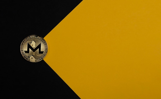 Moneda de oro Monero sobre fondo negro y amarillo como criptomoneda de sobre y criptoinversión