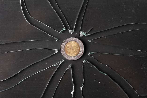 Foto moneda de peso mexicano en concepto de inflación de vidrios rotos