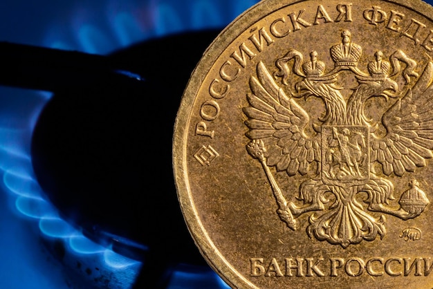 Moneda de rublo ruso en el fondo de un quemador de gas Foto de alta calidad