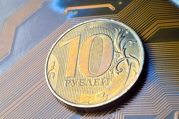 Foto una moneda con un valor nominal de 10 rublos se encuentra en un primer plano de microcircuito traducción de la inscripción en la moneda quot10 rublosquot el concepto de la economía digital en la federación rusa