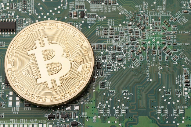 Moneda virtual Bitcoin dorada en un fondo de placa de circuito