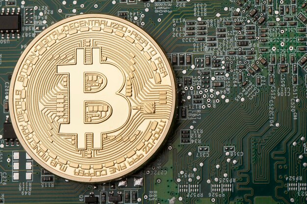 Moneda virtual de oro de Bitcoin en un fondo de placa de circuito