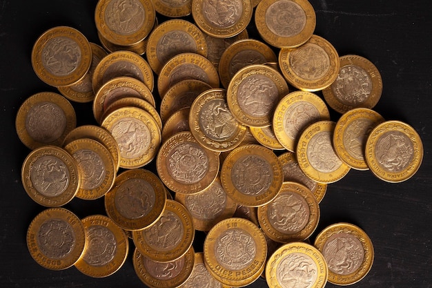 Foto monedas de 10 pesos mexicanos sobre fondo negro