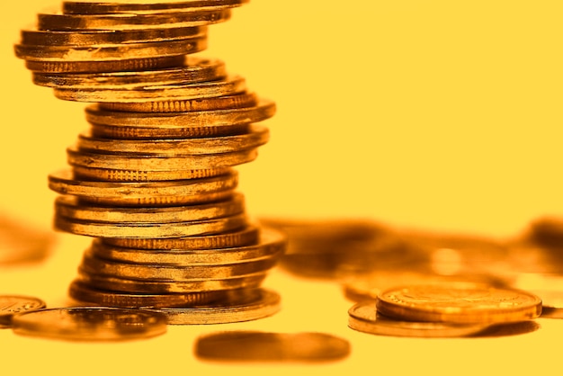 Las monedas apiladas se colocan sobre un fondo dorado.