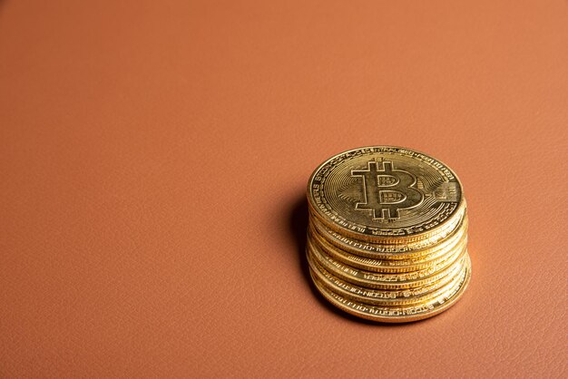 Monedas bitcoin bitcoin colocadas en un enfoque selectivo de fondo de cuero marrón