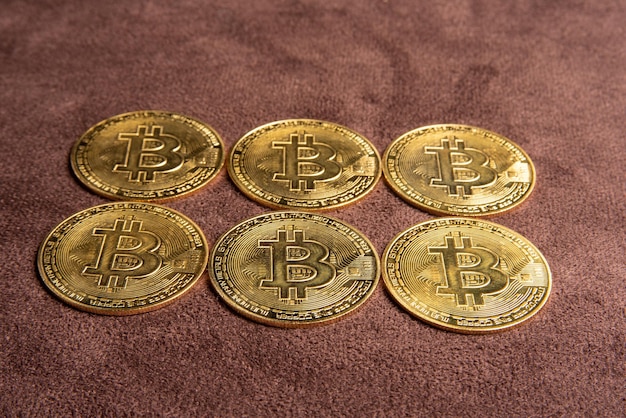 Monedas bitcoin bitcoin colocadas en un enfoque selectivo de fondo de cuero marrón