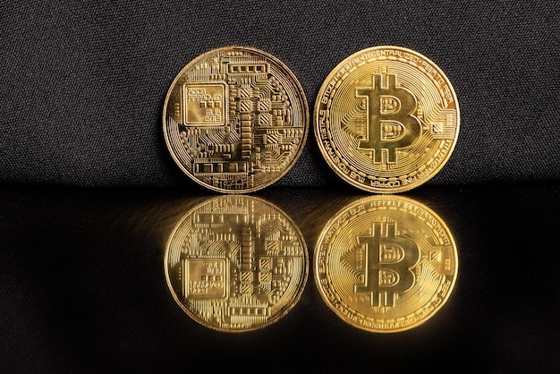 Monedas bitcoin bitcoin colocadas en un enfoque selectivo de fondo reflectante oscuro