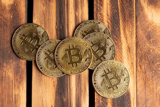 Monedas bitcoin bitcoin colocadas en una vista superior de fondo de madera quemada rústica