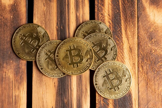 Monedas bitcoin bitcoin colocadas en una vista superior de fondo de madera quemada rústica