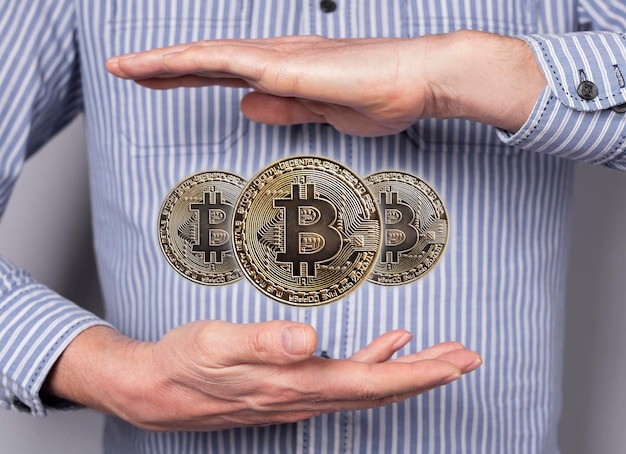 Monedas Bitcoin levitando entre las manos del hombre Dinero digital Cryptocurrency Concepto financiero en estilo abstracto