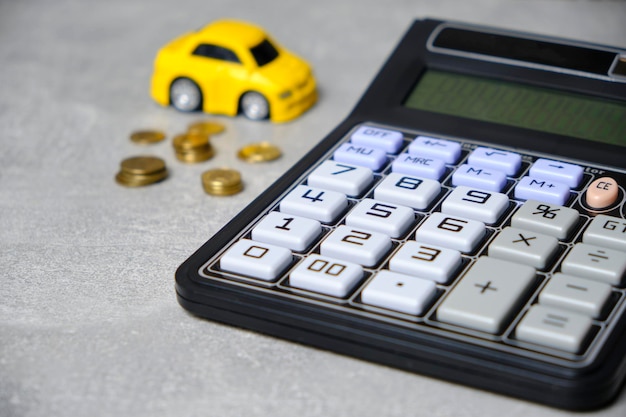 Monedas de calculadora y concepto de automóvil compra de automóvil
