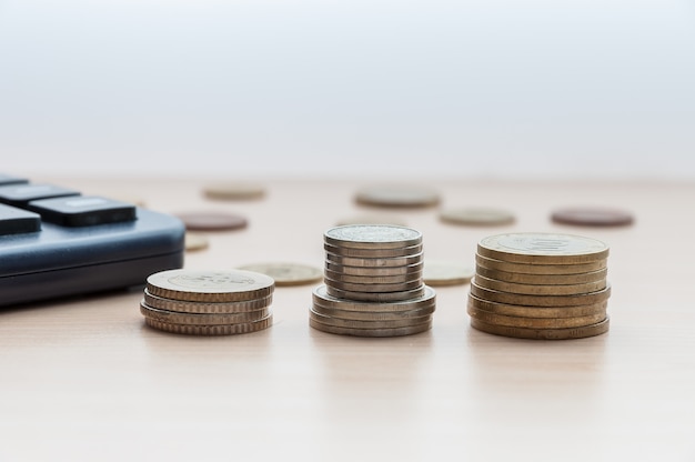 Monedas en las columnas de la mesa de madera.